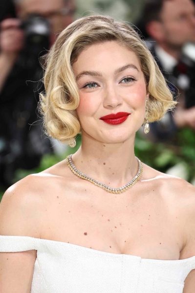 At the 2024 Met Gala, Gigi Hadid wore her wore her bright blonde strands curled away from her face and swept into to a side part.