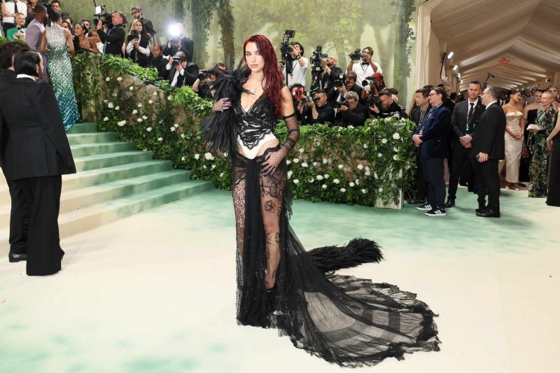 Dua Lipa wore a sheer skirt with a dramatic corset and opera gloves to the 2024 Met Gala. See the look here.