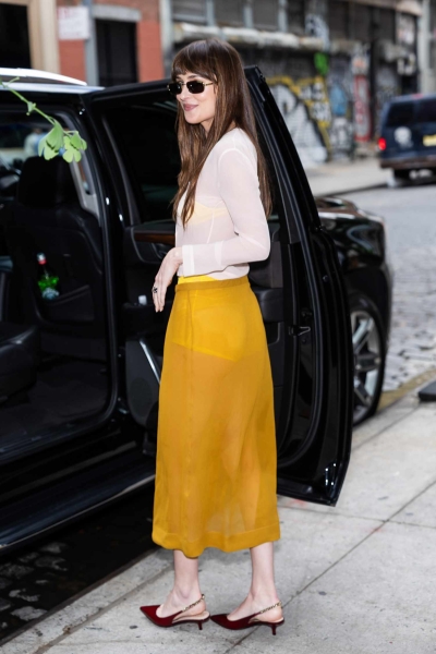 Dakota Johnson wore a sheer Gucci skirt and top in New York City. See her look, including her bright yellow bra-and-underwear set, here.
