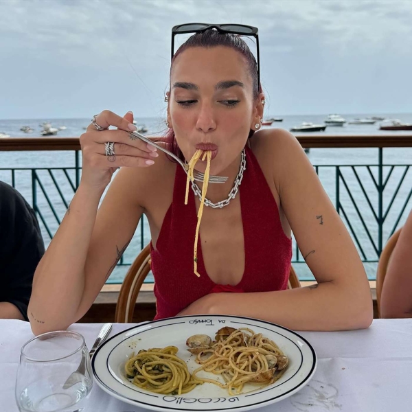 Dua Lipa enjoyed some pasta on a Balcony in Italy while wearing a red crochet halter top. See her case for bringing back the going out top, here.