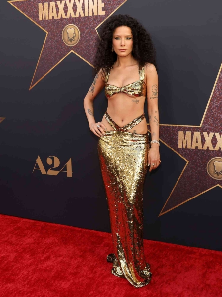 Halsey took inspiration from Cher while attending the world premiere for 'MaXXXine' on Monday, June 24. The "Without Me" singer played homage to Cher's signature beauty look and wore a two-piece gold sequin gown which featured underboob and gigantic hip cutouts.