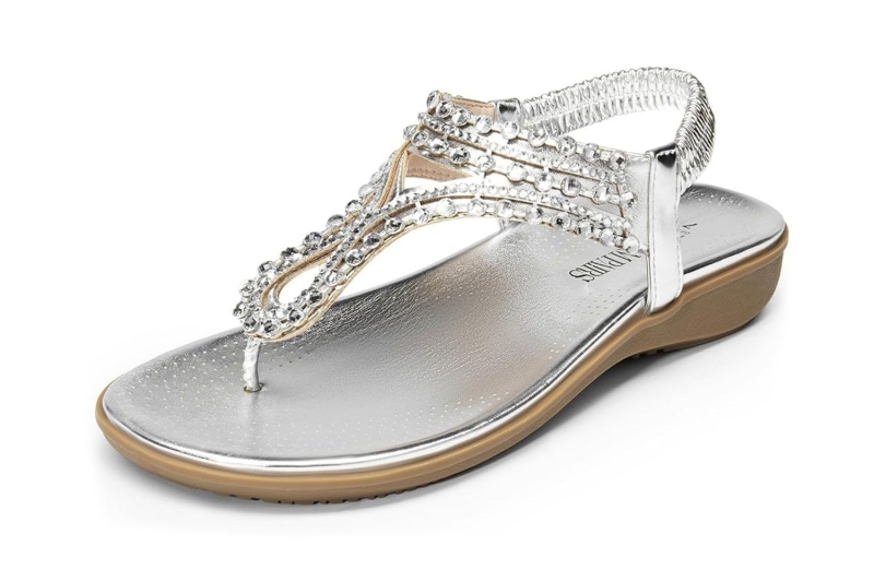 Vera Wang posted an Instagram photo wearing a white one-piece swimsuit and silver slingback sandals by the pool. Shop similar metallic summer sandals and white bathing suits from Amazon, Nordstrom, Zappos, and more.