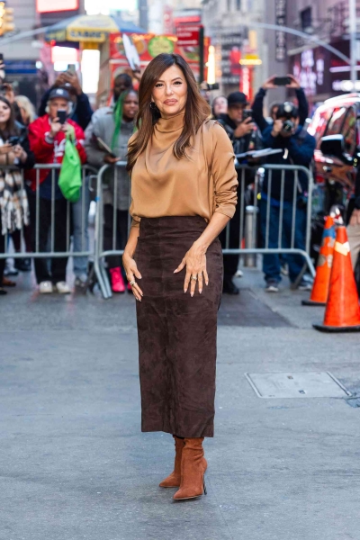 Look of the Day for October 30, 2024 features Eva Longoria in a fall-perfect look that includes a silk turtleneck blouse, brown suede skirt, and suede boots while out and about in New York City.