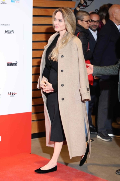 Angelina Jolie attended the 42nd annual Torino Film Festival on November 24 and wore a v-neck sweater, a high waisted midi skirt, and a controversial Y2K shoe—the ballet flat—all in black for her appearance on the red carpet for the event.