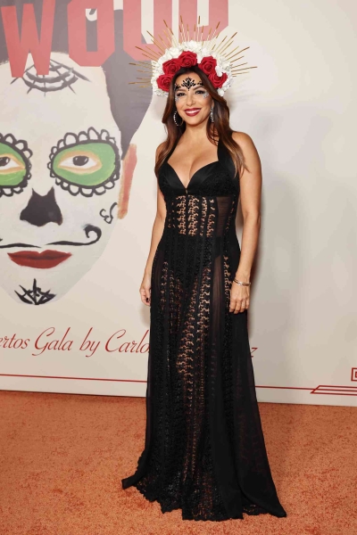 Eva Longoria wore a plunging, sheer LBD and striking floral headpiece to Carlos Eric Lopez's Day of the Dead gala. See her bold look, here.