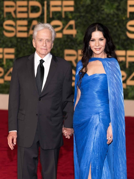 Catherine Zeta-Jones hopped aboard the witchy woman trend with her dramatic cobalt blue cape dress on a date night with Michael Douglas. See photos.