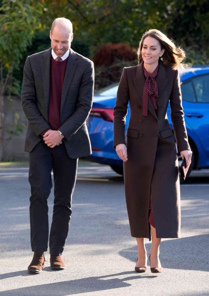 Kate Middleton arrived at her annual Christmas Carol concert wearing a floor length red pea coat that feature a large, black velvet bow at the neckline. She accessorized with velvet black boots.