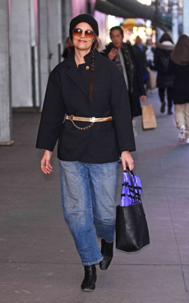 Katie Holmes was spotted on December 18, 2024, wearing a black coat with a bright gold belt along with blue jeans and black leather boots. See the outfit here.