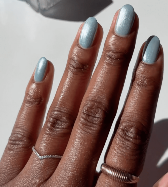 An icy blue nail look can complement a winter white outfit or a cozy gray sweater. So pairing a layer of chrome powder with shades of periwinkle, navy, or teal creates the perfect look.